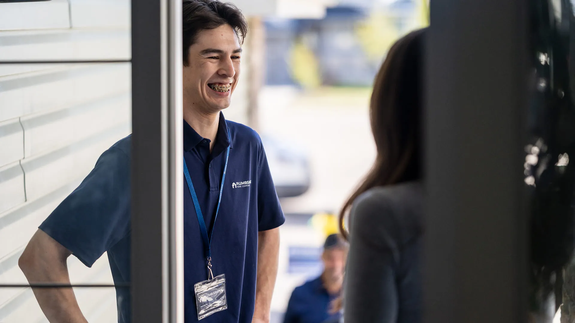 Smiling-Technician-Talking-To-Homeowner-At-Front-Door