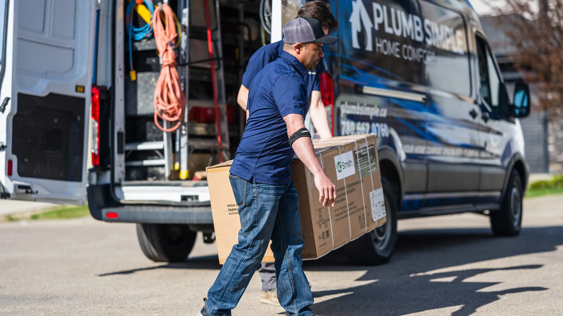 Technician-Carrying-AO-Smith-Water-Heater-Box-From-Van