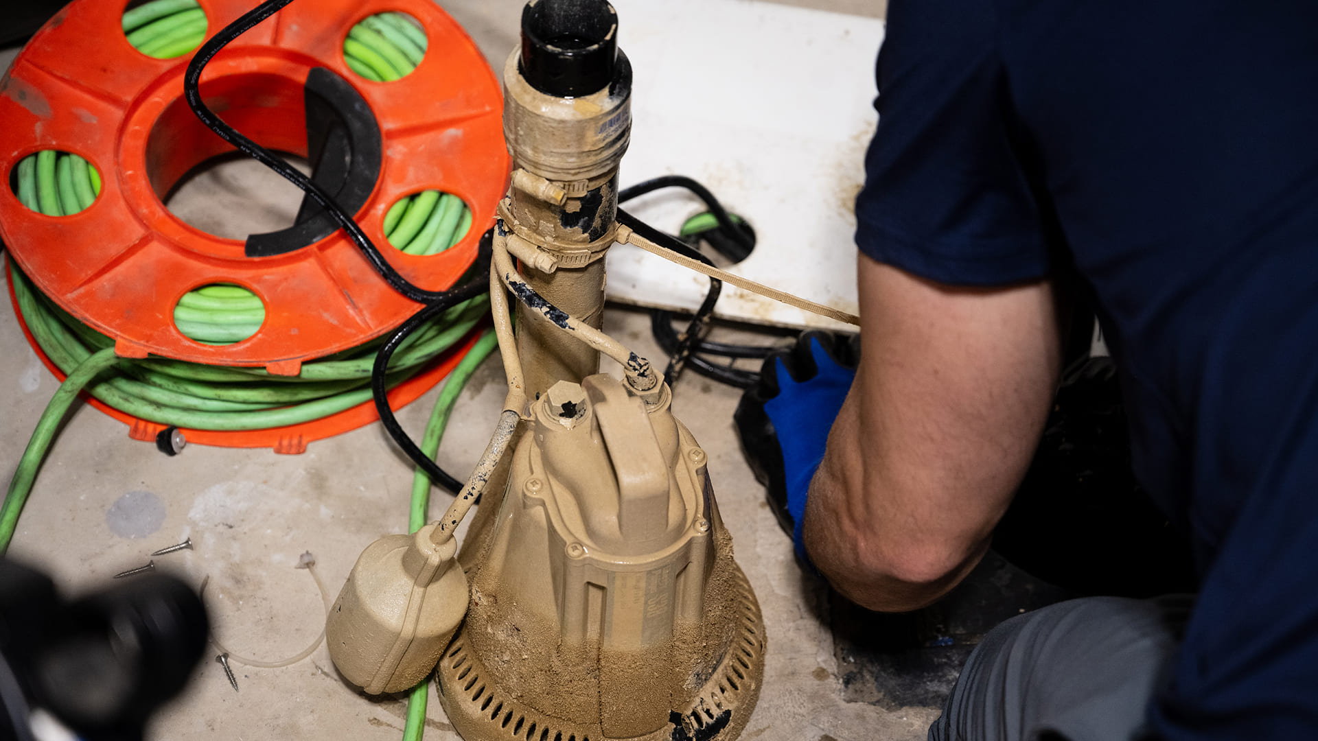 Technician-Inspecting-Sump-Pump-In-Basement