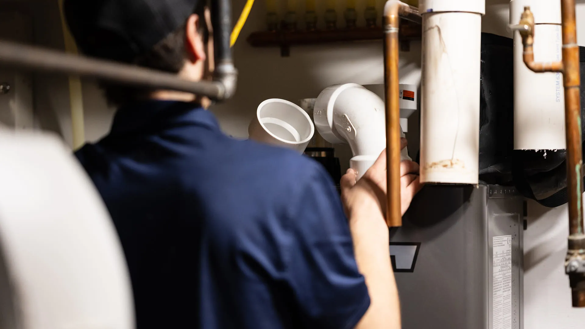 Technician-Fitting-PVC-Elbow-Joint-On-Furnace-Venting