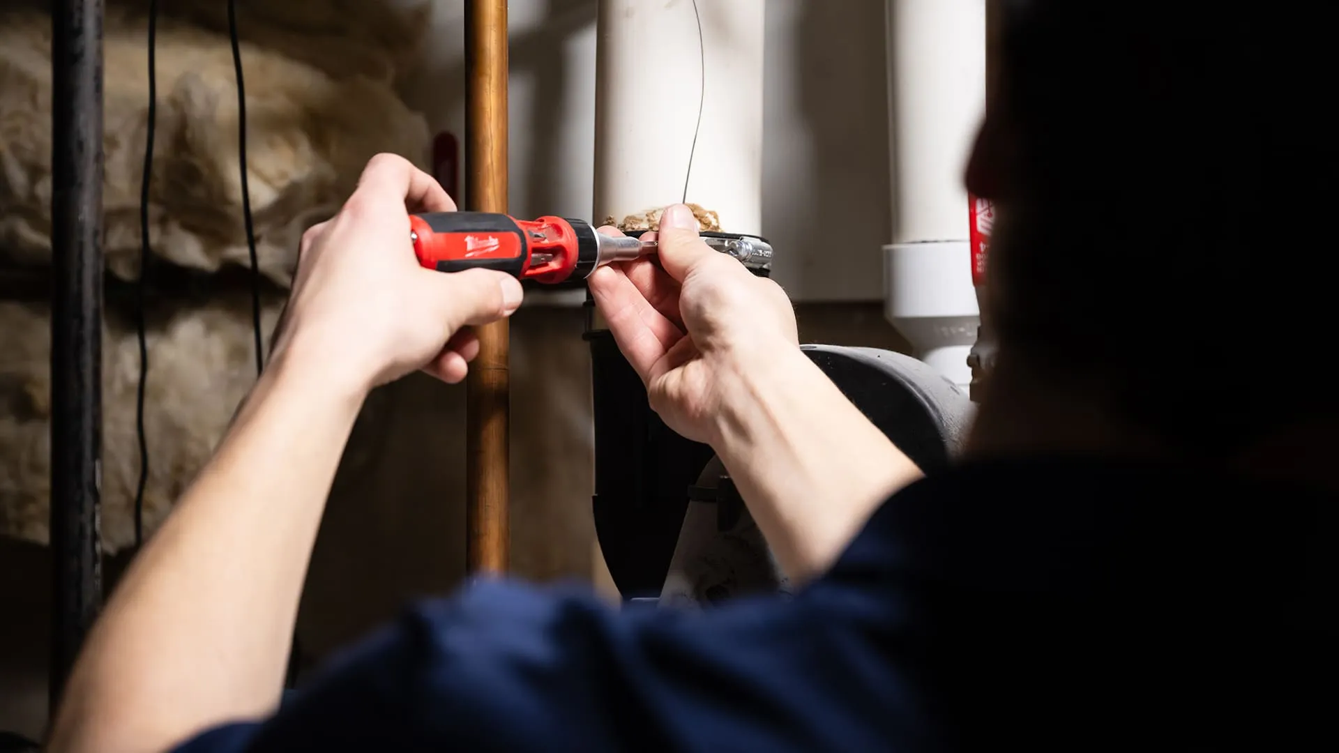 Close-Up-Of-Plumber-Using-Screwdriver-On-Pipe-Clamp