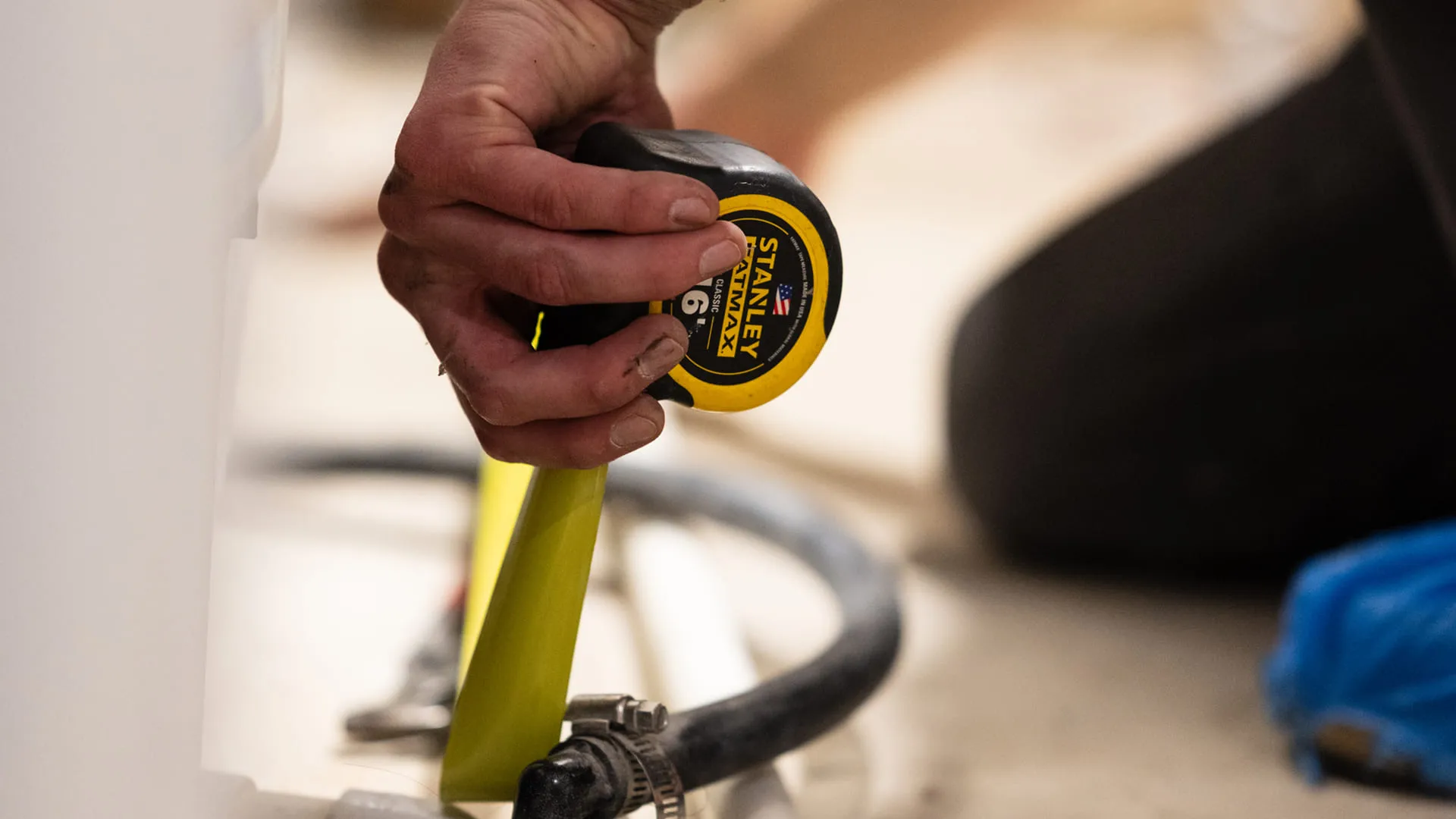 Close-Up-Of-Technician-Taking-Measurement-With-Tape-Measure