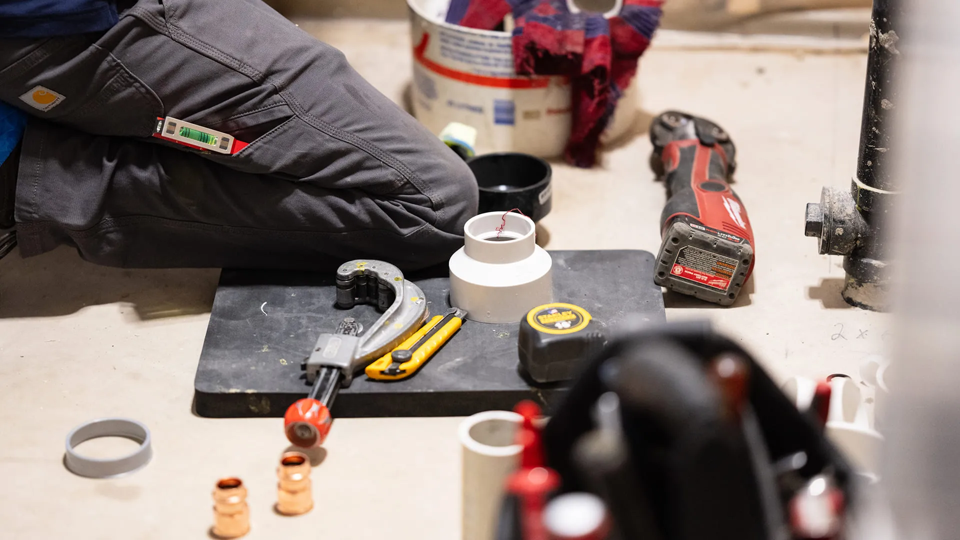 Plumbing-Tools-And-Pipe-Fittings-Arranged-On-Floor